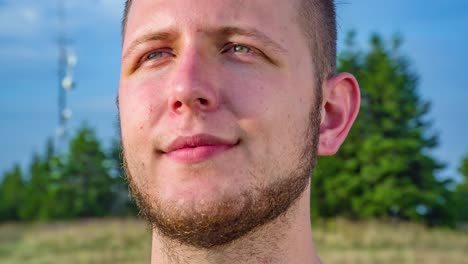toma panorámica izquierda de la expresión facial tranquila y positiva de un hombre adulto joven