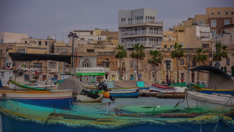 pequeños barcos coloridos y el municipio maltés detrás, vista de lapso de tiempo