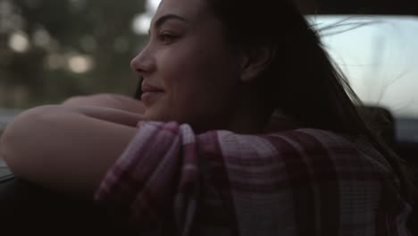 young woman looking out of the window's car while having a road trip