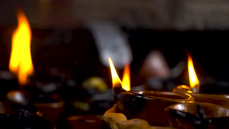 closeup of burning diyas, celebrating diwali festival.