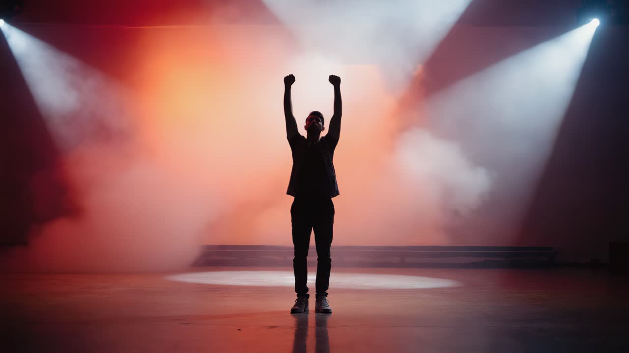 Man silhouetted on stage with spotlights and fog