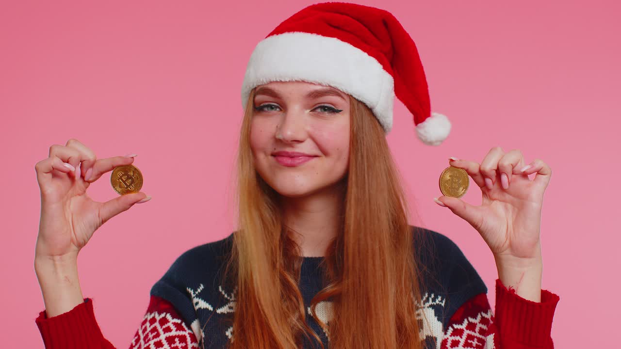 Girl in christmas sweater showing golden bitcoins btc cryptocurrency money investment mining future