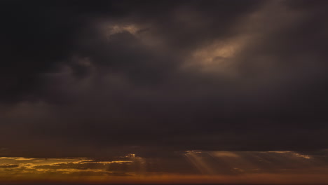 Sunrays-Radiating-Through-Dark-Storm-Clouds-Covering-The-Sun-At-Sunset