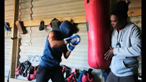 boxeador afroamericano practicando boxeo con un entrenador en un estudio de fitness 4k