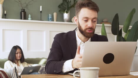 businessman sitting at table, having a video call on laptop computer 1