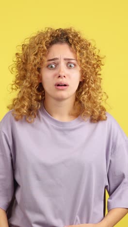 young woman with curly hair expressing surprise and concern