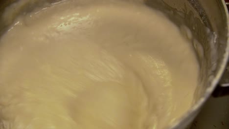 detalle de un cuenco con una mezcla gruesa de harina blanca golpeada con un mezclador de mano