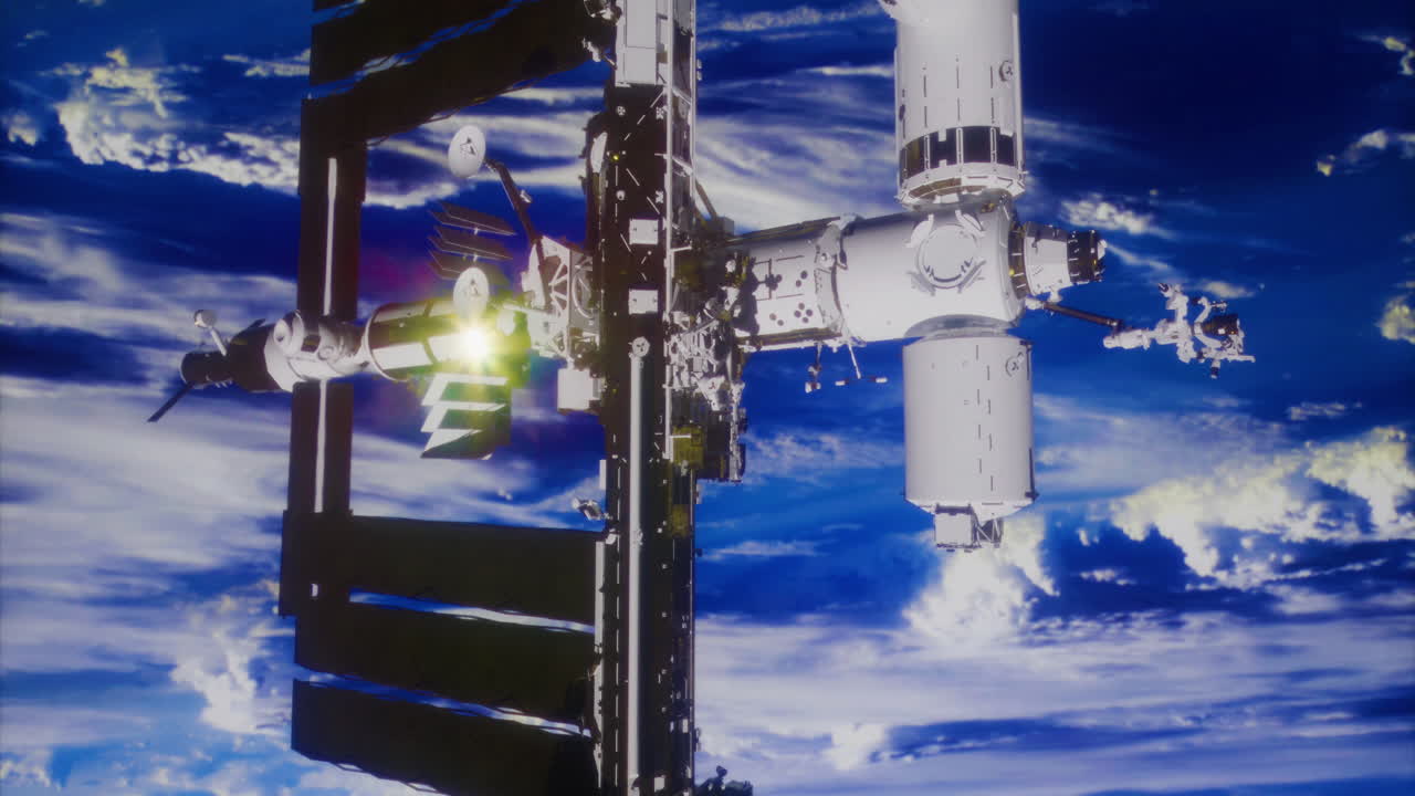 La ISS orbita attorno alla terra con i pannelli solari estesi in un cielo azzurro limpido