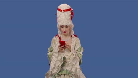 portrait of courtier lady in white vintage lace dress and wig texting on her phone. young woman posing in studio with blue screen background. close up. slow motion ready 59.94fps