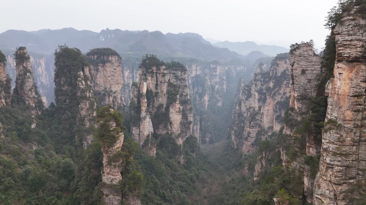 An expansive drone shot capturing the iconic rock formations and lush valleys of Zhangjiajie, China, offering a stunning view of this famous natural landscape