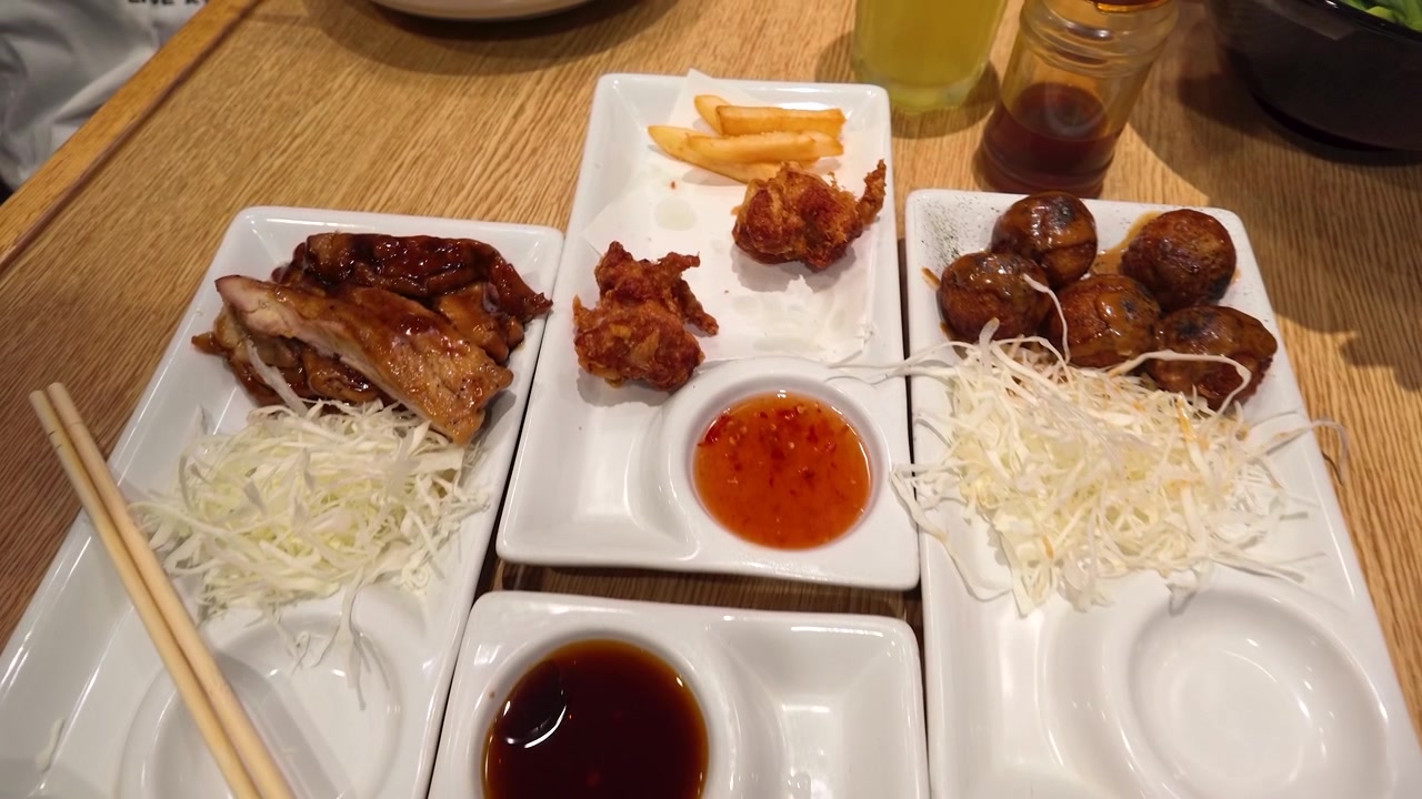 Pemandangan dari atas pengunjung yang menggunakan sumpit untuk makan gyoza, takoyaki, dan ayam teriyaki