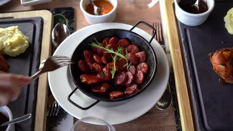 Hand-with-a-fork-taking-a-chorizo-pork-sausage-meat