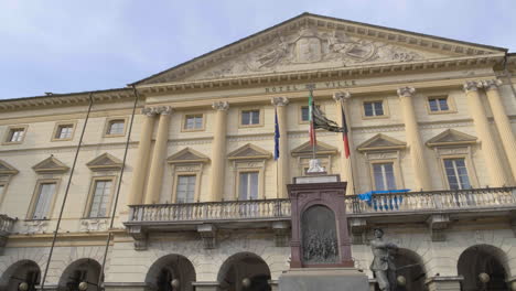 a close-up panning view of the large neoclassical-style building with a porch and the statue of the town hall, aosta valley, italy