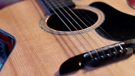 a big close up of a bass guitar strings with its base, light reflections and focus shifting on the guitar