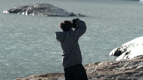 Photographer-shooting-in-to-Ojo-del-Albino-glacier-in-Ushuaia,-Argentina