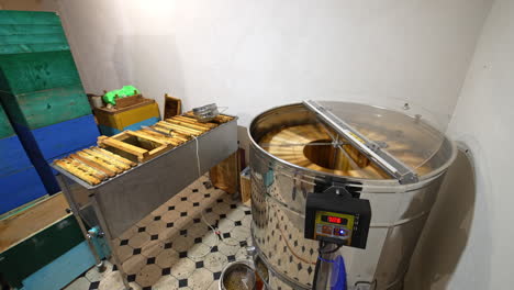 beekeeper's room for storing wooden hives and extracting honey. centrifuge mechanism working rotating frames to collect honey.