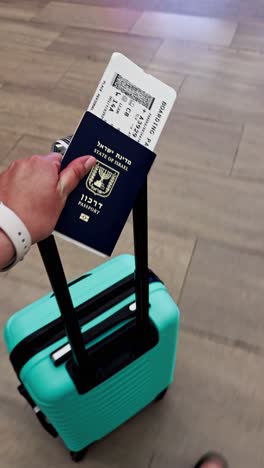 pov of traveler with israeli passport and suitcase