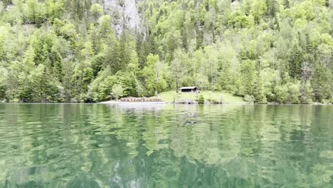 Boat-ride-on-picturesque-lake-Königssee-near-Berchtesgaden-in-the-Bavarian-Alps-passing-by-a-tourist-boat-near-the-shore