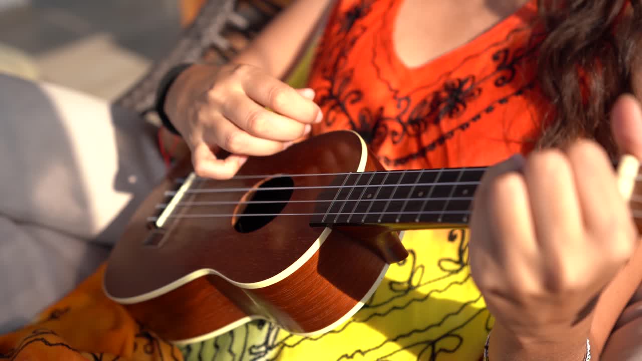 Young woman playing the ukulele. sunny and colourful.