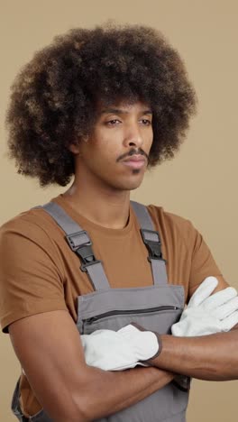 man in overalls with afro and gloves