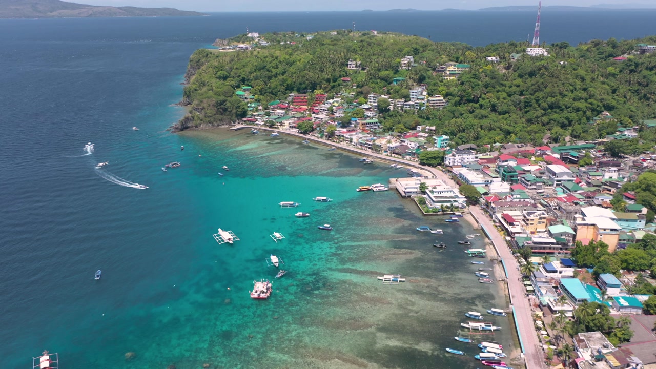 A stunning drone video captures Puerto Galera and Sabang with turquoise waters, boats, and diving schools, showcasing the tropical beauty of this famous Philippine destination.