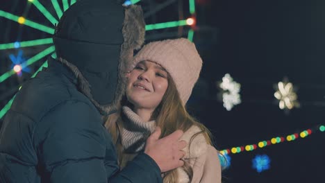 man-touches-girl-hair-by-Ferris-wheel-at-fair-slow-motion