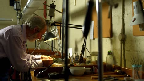 goldsmith working at desk in workshop 4k