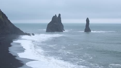 beautiful seascape of reynisfjara, black sand beach. aerial flying backwards