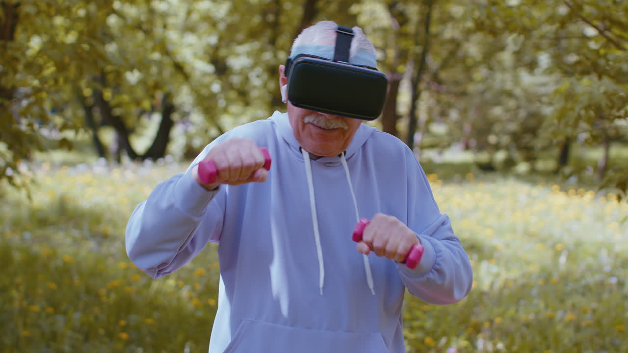 Anziano che si allena, facendo esercizi con manubri, indossando un visore VR e giocando a un videogioco