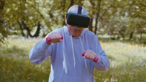 Senior-man-exercising,-making-dumbbell-weight-lifting-exercises,-wearing-VR-helmet-play-video-game