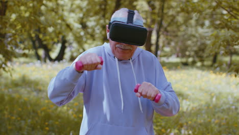 hombre mayor haciendo ejercicio, haciendo ejercicios de levantamiento de pesas con pesas, usando casco vr jugando videojuegos