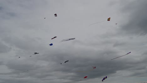 multiple colourful kites flying high in the sky captured in slow motion