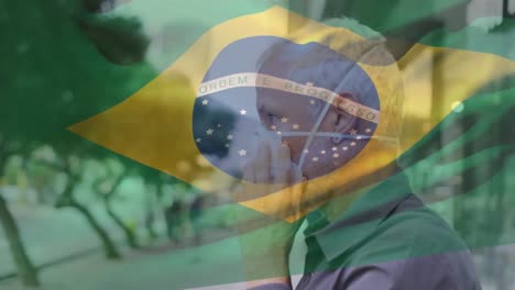 Animation-of-flag-of-brazil-waving-over-man-in-face-masks