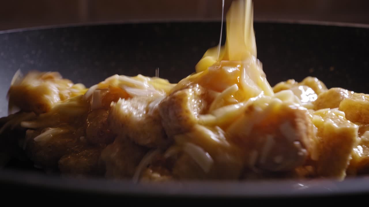 Estremo primo piano di una padella calda, con il composto per l'omelette tostata che viene versato