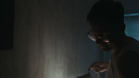 a sad man reads a book at night in his underwear