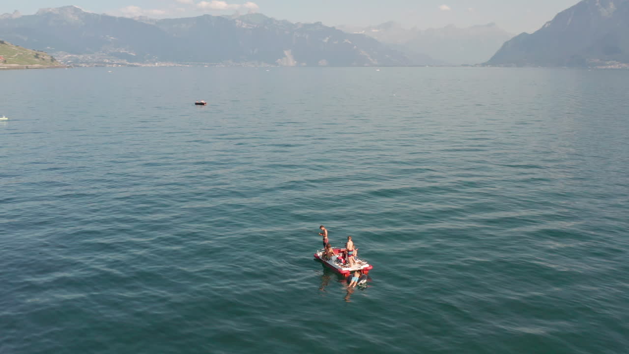 Aerial of kids on a paddle boat in a large beautiful lake