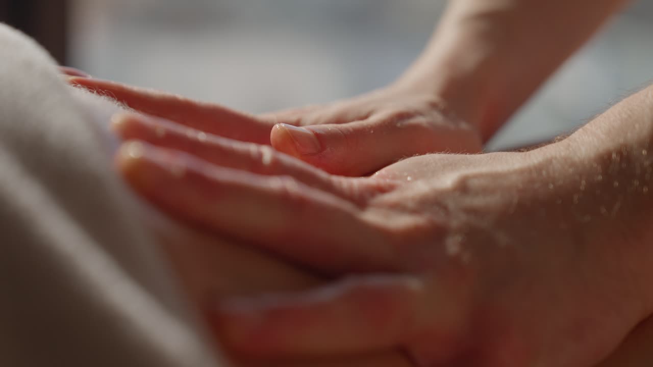 Close-up of Hands Massaging a Person's Back with Oil