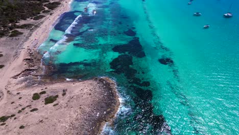 scenic aerial view of rocky island formentera's turquoise azur waters and sandy beaches. majestic aerial view flight tilt up drone
