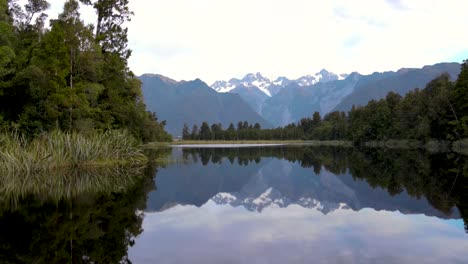 stunning alpine scenery is reflected in lake matheson surrounded by lush native forest