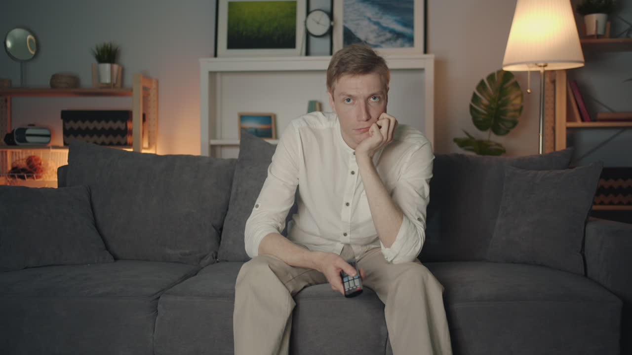 Man Bored on Couch Watching TV