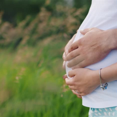 hombre y mujer embarazada sosteniendo el vientre