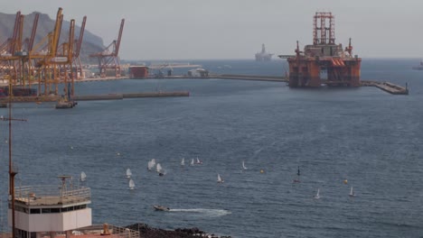 sailboat regatta next to a busy shipyard time-lapse