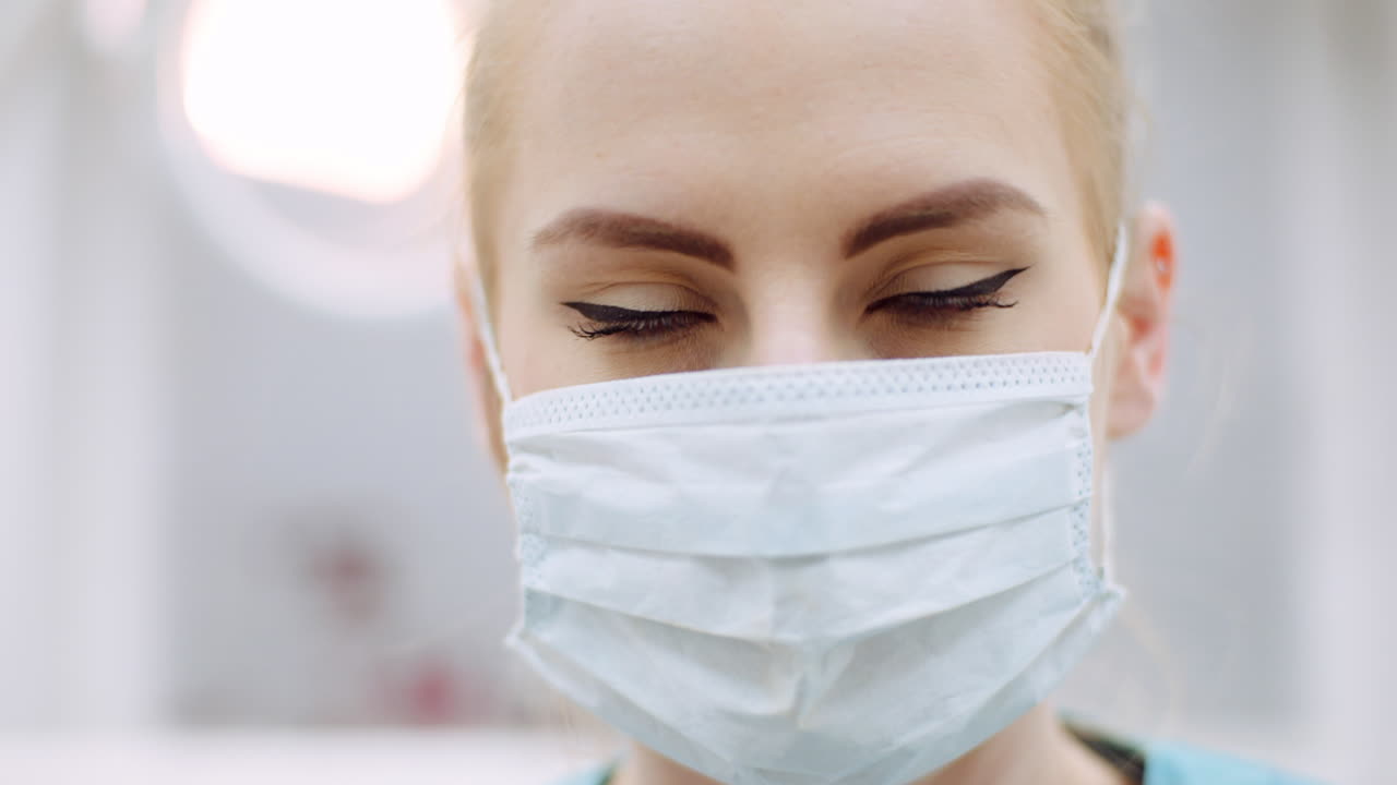 primer plano de una dentista mirando al paciente durante la cirugía 1