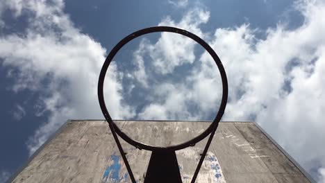 basketball shooting through the hoop of an old, weathered basketball ring -slowmo