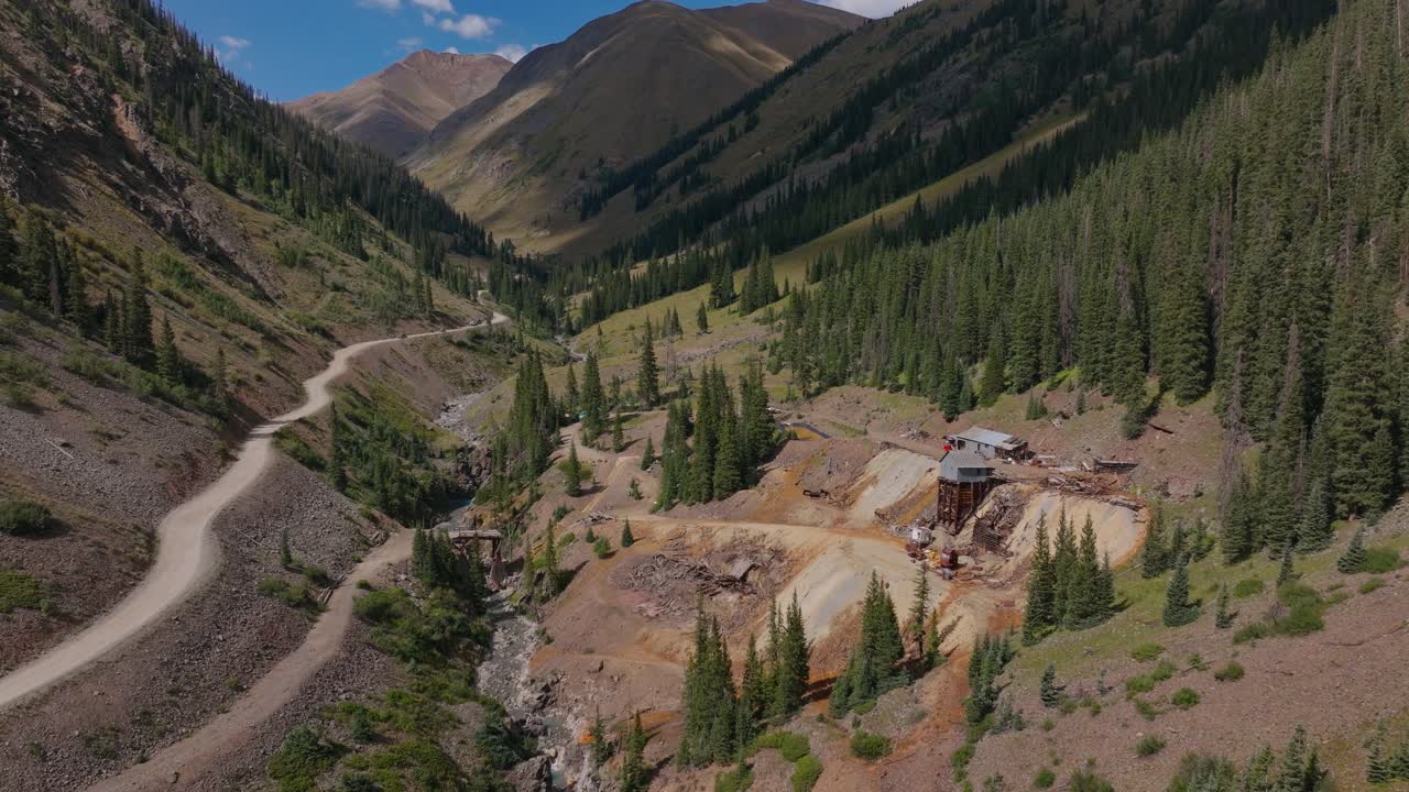 Estructuras en ruinas de la ciudad minera de Animas Forks, rodeadas de escarpado terreno alpino, vista aérea de alejamiento, Trans America Trail, Colorado, EE. UU.