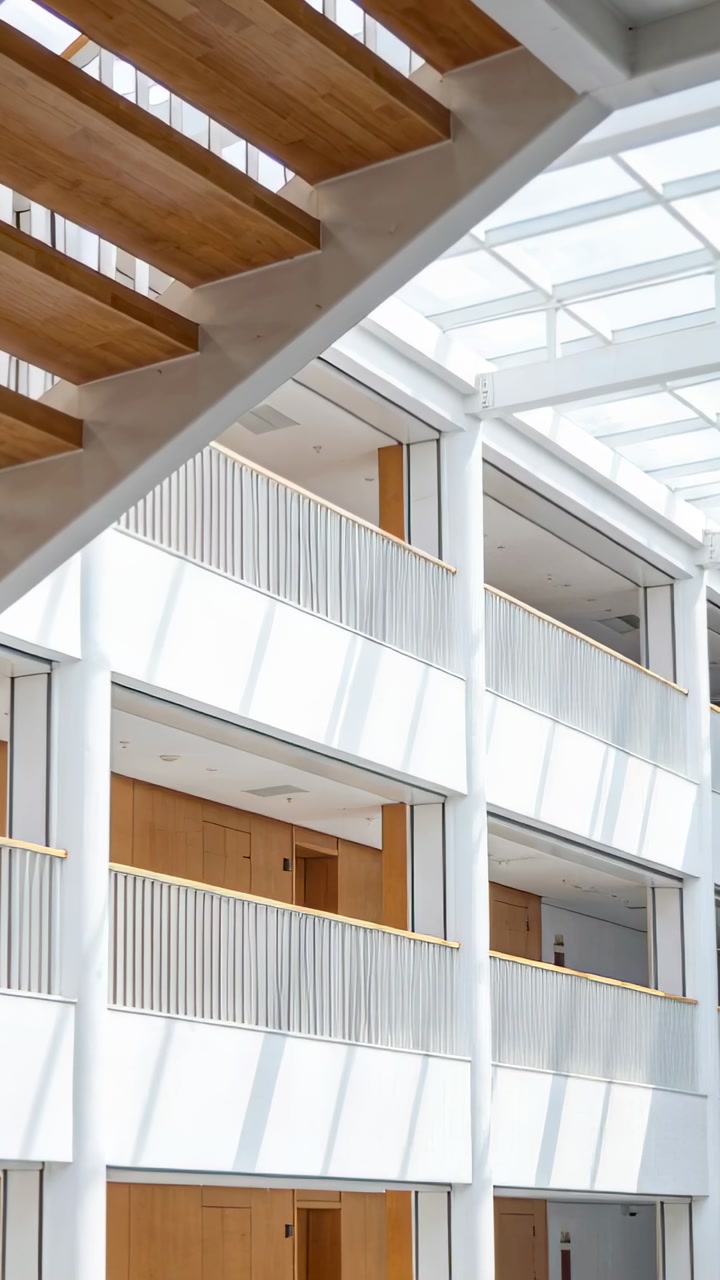 Camera panning upward in atrium, revealing diagonal wood treads, skylight grid, railings for design