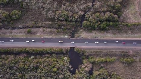 line of cars queuing on rural rectilinear road of uruguay in south america