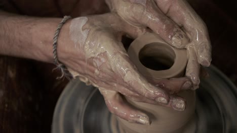 the potter makes a jug of clay. ceramist. a man makes a vase on a potter's wheel