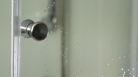 hand on shower door handle