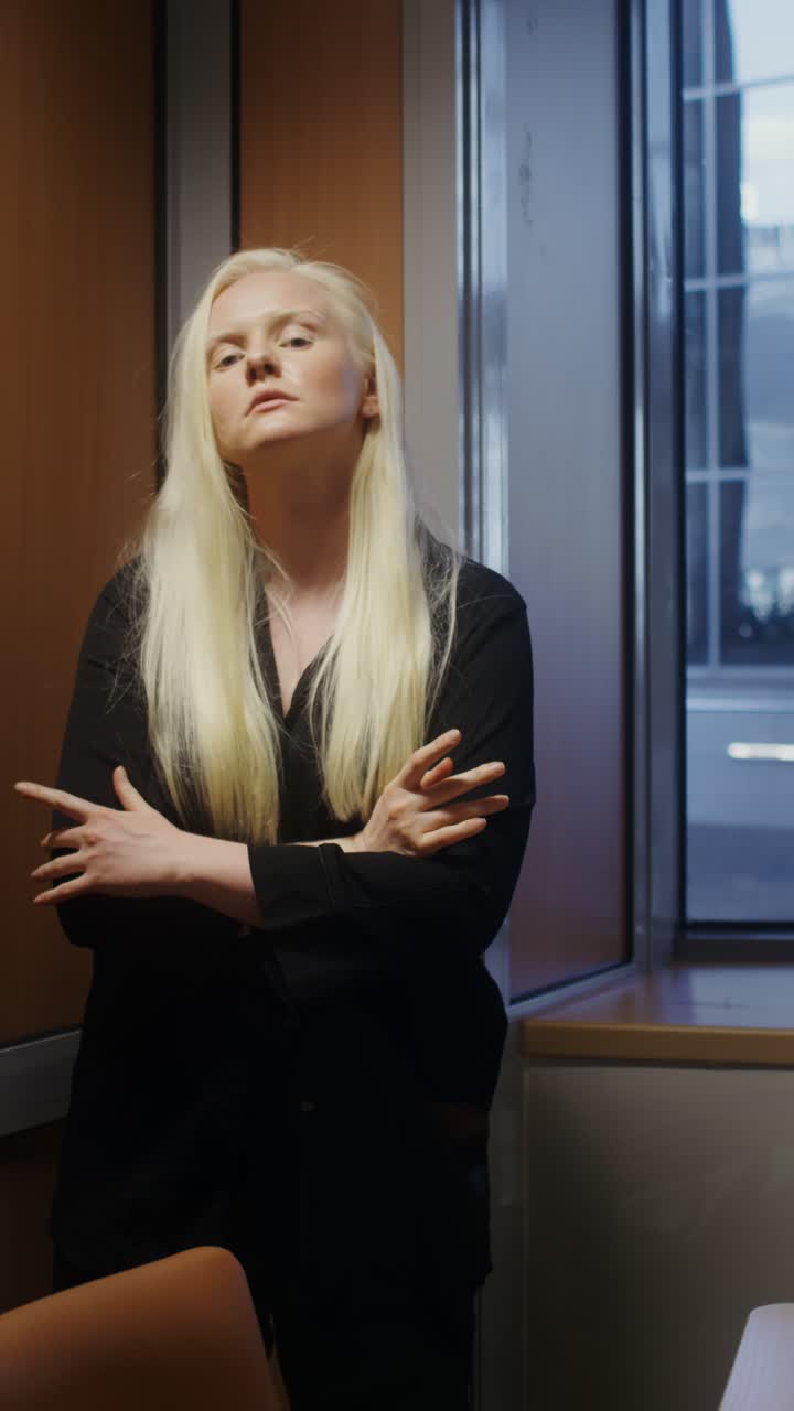 Donna in maglietta nera che posa in interni